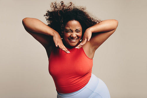 Excited woman moving her fit and curvy body in a fun dance workout