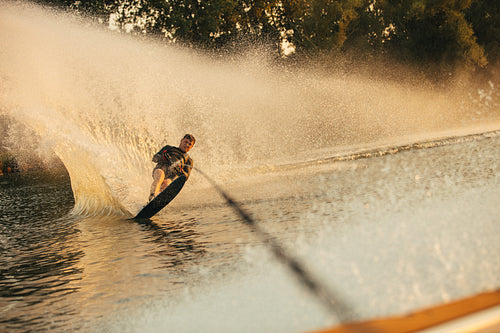 Wakeboarder surfing across the lake