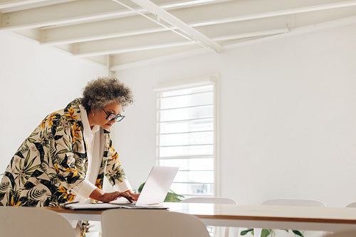 Mature businesswoman using a laptop in a creative office
