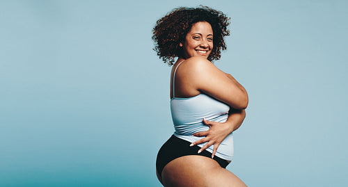 Woman proudly embracing her body in a workout studio