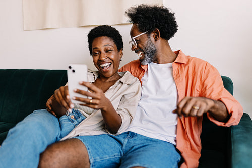 Couple connecting with their friends through a video call at home