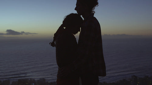 Loving couple on hill top at dusk