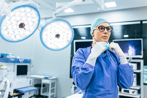 Female surgeon with surgical mask at operating room