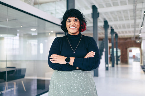 Smiling businesswoman standing with her arms crossed