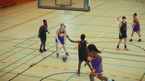 Young people playing basketball indoors