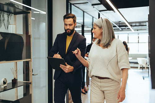 Colleagues having a discussion while walking in an office