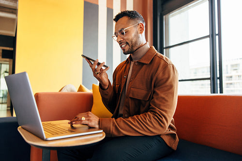 Smiling businessman taking a phone call in an office lobby