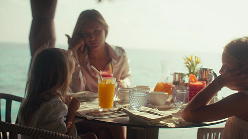 Happy family enjoying a delicious breakfast together at an island resort on vacation