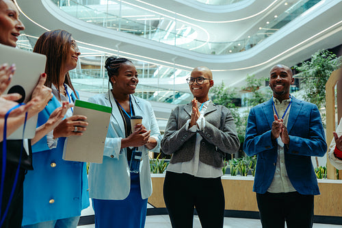 Diverse group of professionals in business attire engaged in a greeting at a modern law firm office