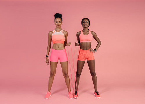 Two women doing exercises with resistance band