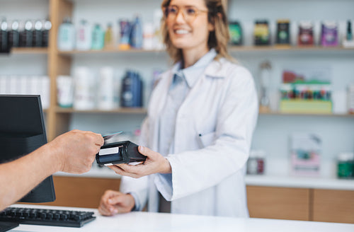 Pharmacist getting a credit card payment in a drug store