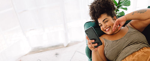 Attractive female using smart phone on sofa