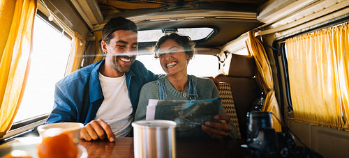 Couple enjoying road trip in a cozy camper van