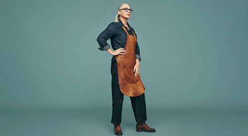 Contemplative female goldsmith standing in a studio