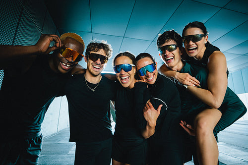 Outdoors, running friends gather in a playful fitness group after training