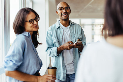 Business man standing with his colleagues and using a mobile phone