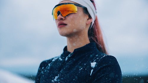 Athlete posing confidently in snowy winter landscape with sportswear