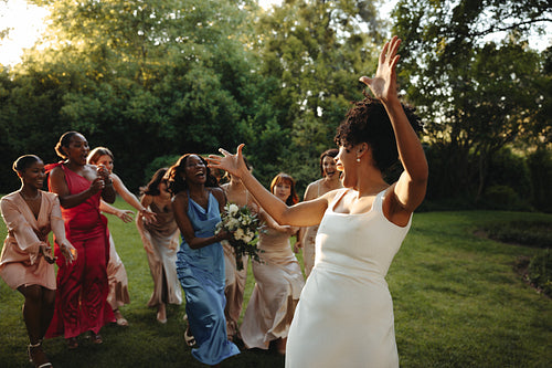 Bride tossing the bouquet during an outdoor wedding celebration