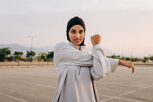 Beautiful Muslim woman warming up outdoors