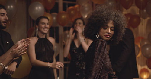 Woman dancing at gala night surrounded by her friends