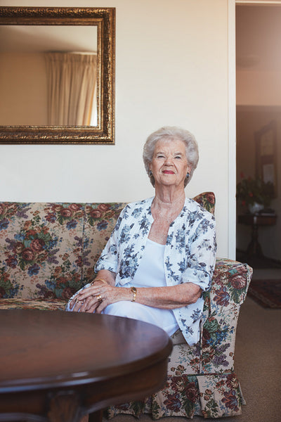 Elderly woman sitting on a couch at old age home
