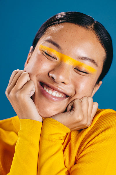 Woman wearing a bold, straight line eyeliner gives her face a warm embrace