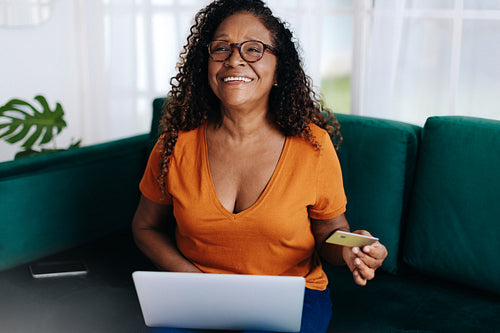 Mature woman shopping online using a retiree credit card