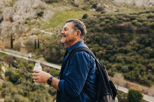 Senior man taking a water break on a hilltop