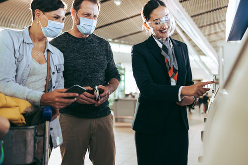 Airport staff helping passenger couple