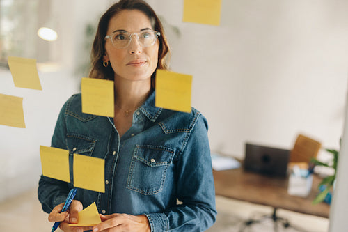 Brainstorming session: Businesswoman generating ideas using sticky notes