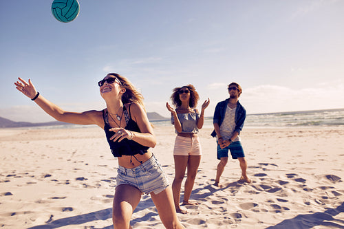Friends playing beach volleyball