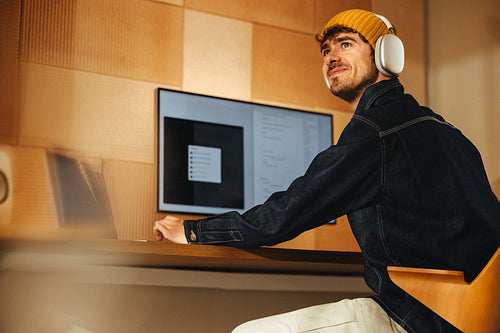 Working at a computer desk with headphones in a modern home office