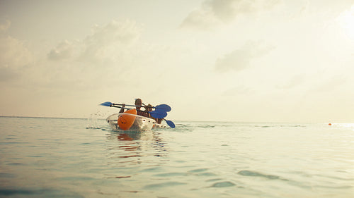 Family kayaking on tranquil tropical waters during a beautiful sunset vacation
