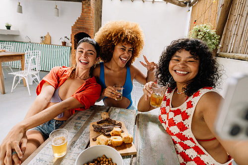 Three friends posing together while enjoying a lunch of pão de alho and churrasco