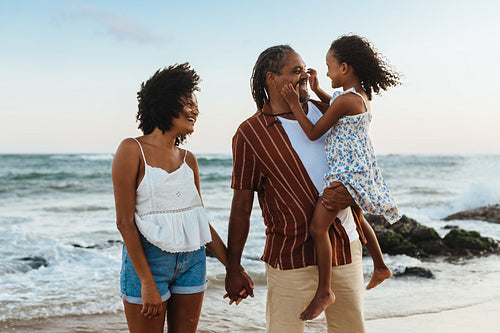 Happy parents spending quality time with daughter on a beach vacation