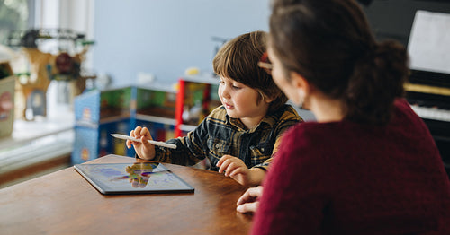 Boy drawing on digital tablet at home
