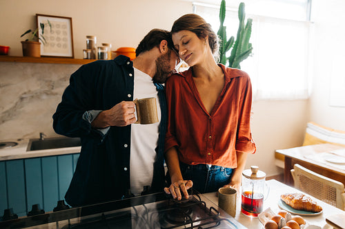Couple in kitchen sharing a cozy morning moment