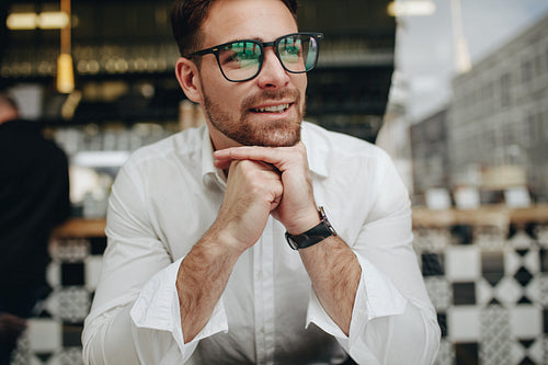 Smiling man sitting relaxed in a cafe