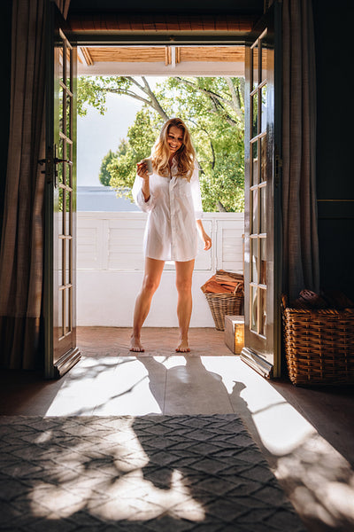 Happy young woman standing at a hotel entrance