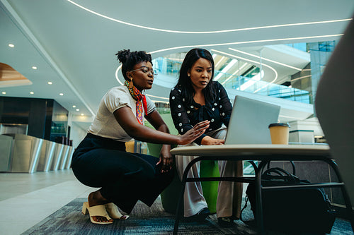 Female colleagues collaborating in a modern corporate office space