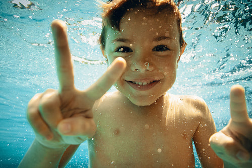 Cheerful young boy enjoying an underwater adventure on vacation
