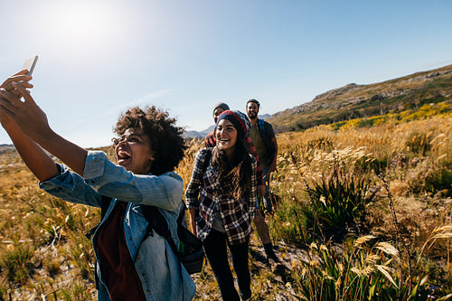 Woman taking pictures of friends while hiking