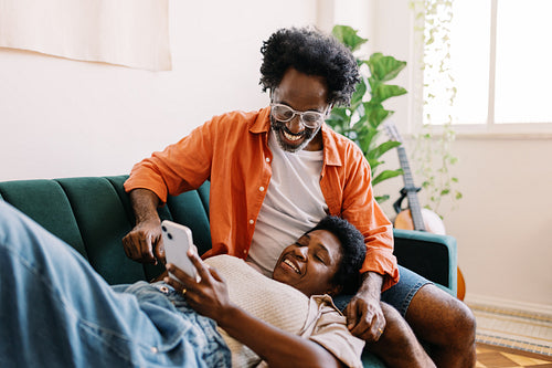 Mature couple enjoying quality time with a smartphone in their living room