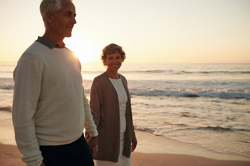 Senior woman with her husband strolling on the beach