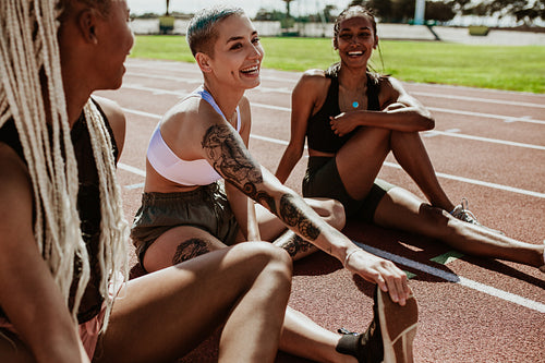 Athletes relaxing after running workout at stadium track