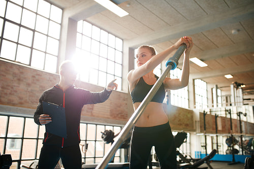 Woman exercising with fitness trainer in gym