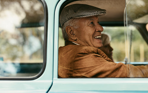 Senior couple traveling in a vintage car
