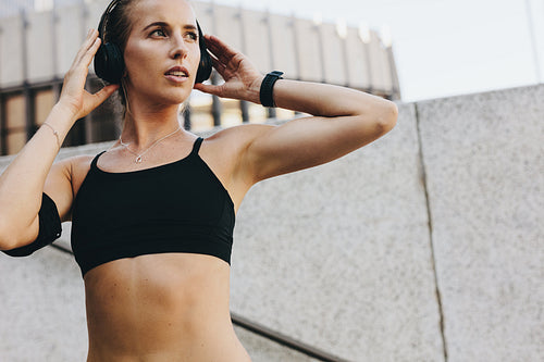 Female athlete listening to music during workout