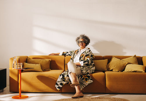 Cheerful businesswoman sitting on a couch in a coworking office