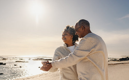 Happy senior couple dancing at the beach
